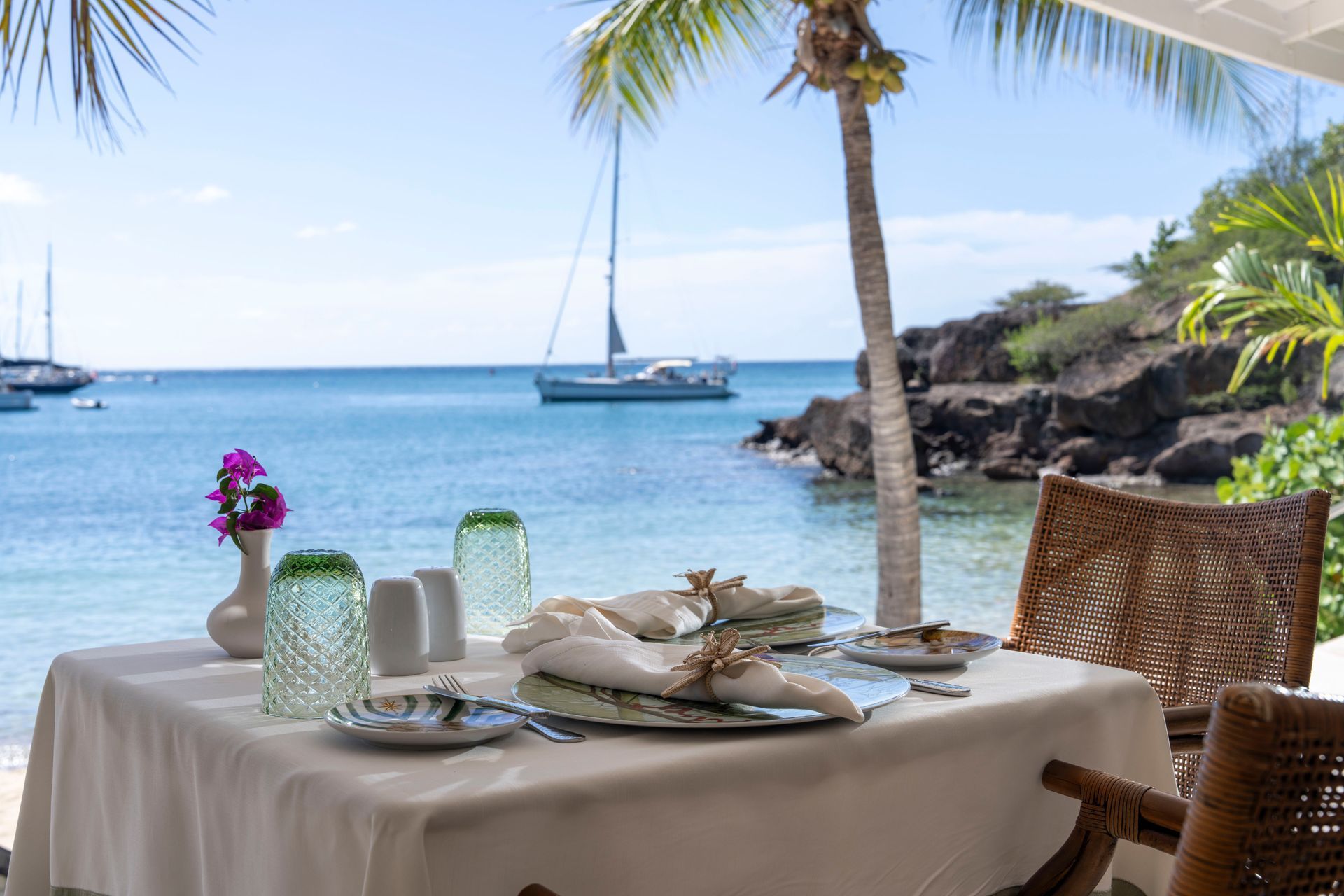 Beachside dining table setting with ocean view at The Inn at English Harbour