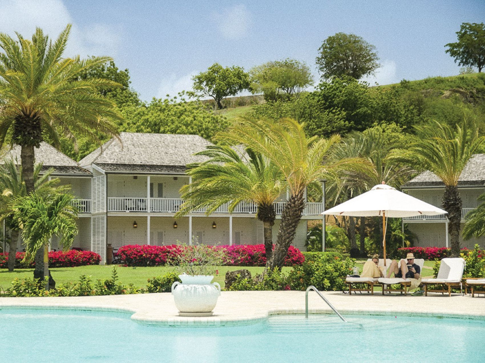 Pool loungers, umbrellas, and suites at The Inn at English Harbour, Antigua